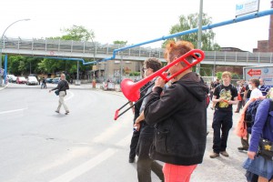 Tobias Trommer gibt mit einer roten Posaune den das Signal zum Flashmob A100 stoppen!