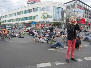 Tobias Trommer gibt mit einer roten Posaune das Signal zum Flashmob A100 stoppen!